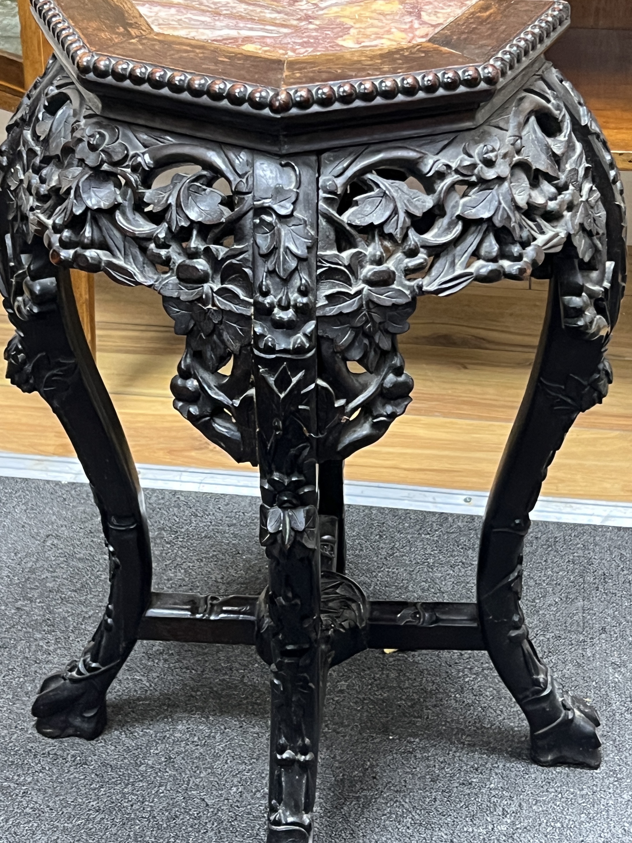 A Chinese octagonal marble topped hardwood jardiniere stand, width 38cm, height 61cm